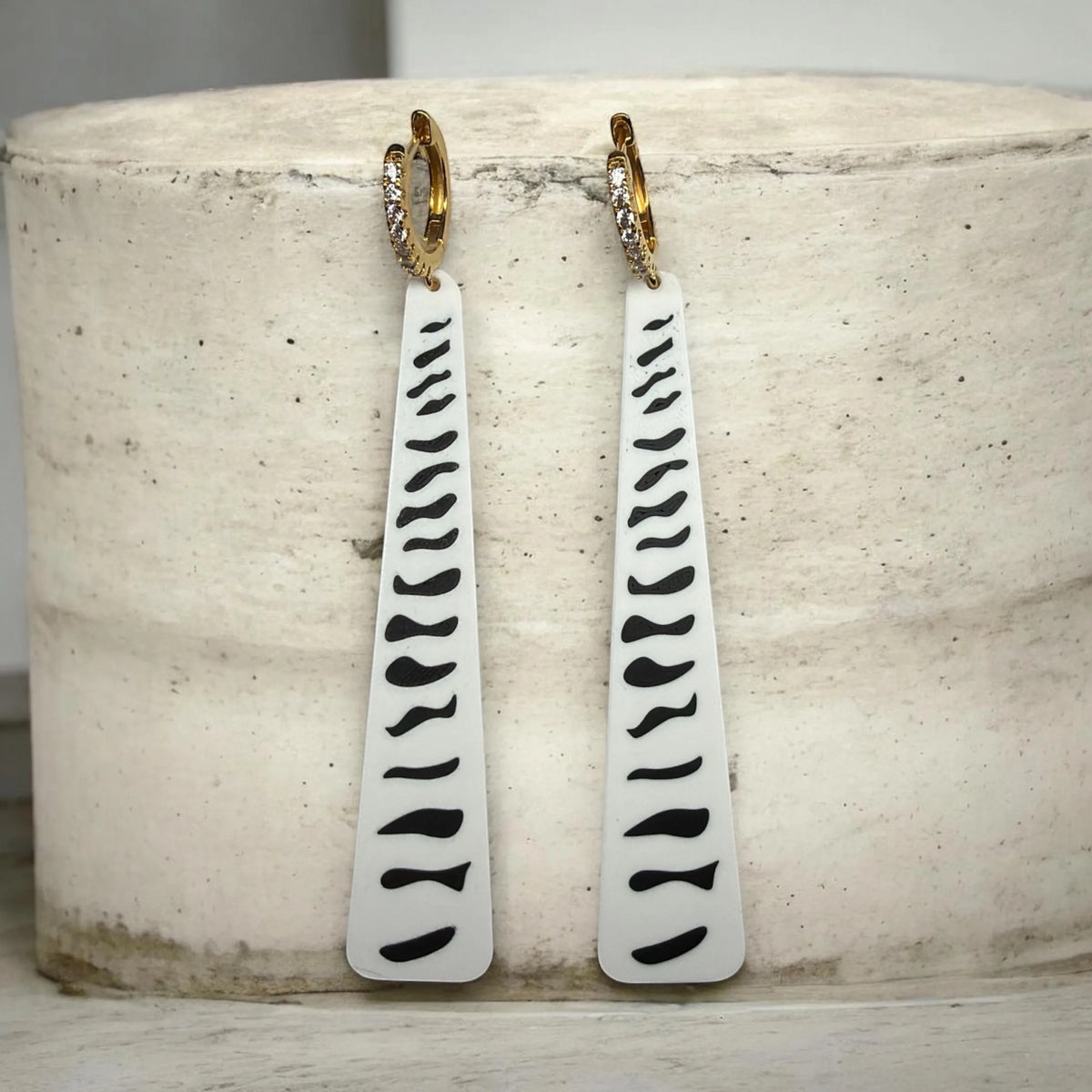 RISITEC - Timeless By Design long drop earrings with white and black abstract patterns, and crystal-encrusted gold hoops.